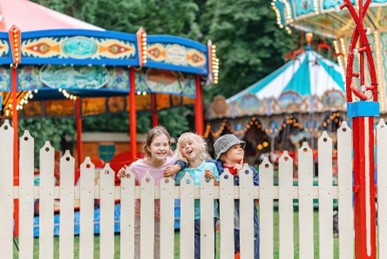 Three smiling children at a fair